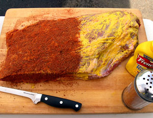 Prepare the brisket with mustard and a layer of rub